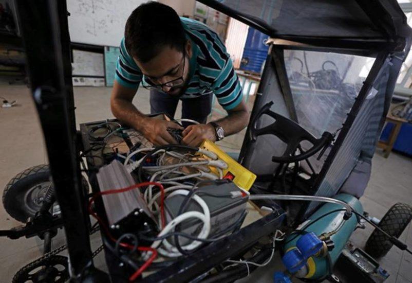 Islam Ibrahim - một sinh viên trong nhóm thiết kế đang chỉnh lại các dây cáp điện trên chiếc xe..jpg